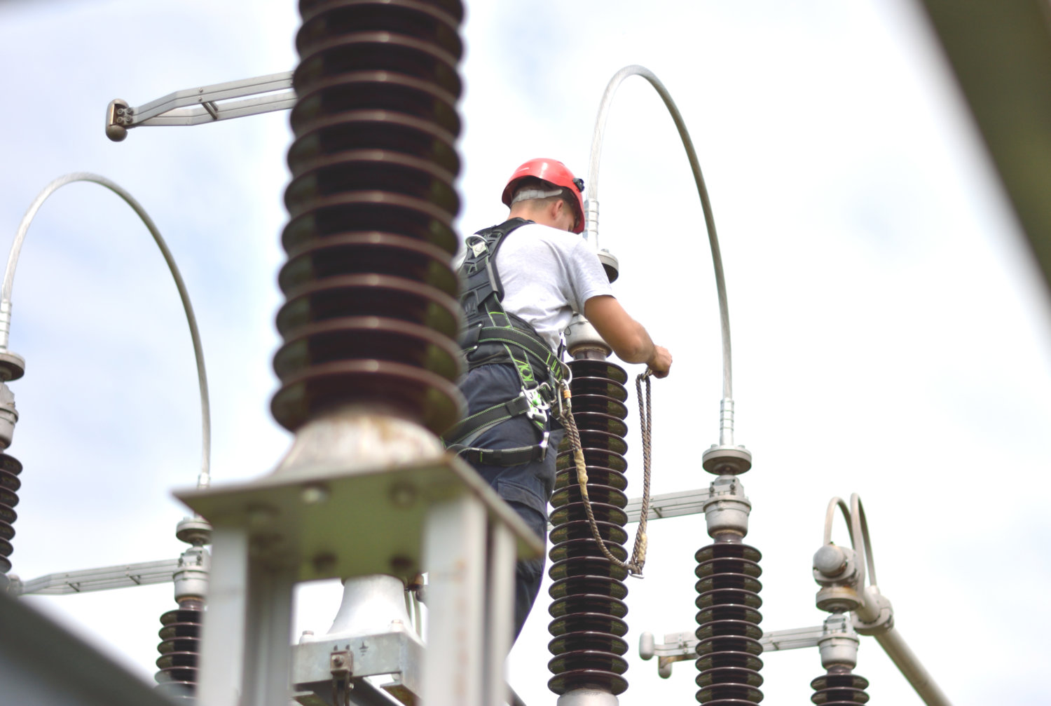 Electrician with Protective Workwear, Hardhat and Safety Harness Working for facilities maintenance.