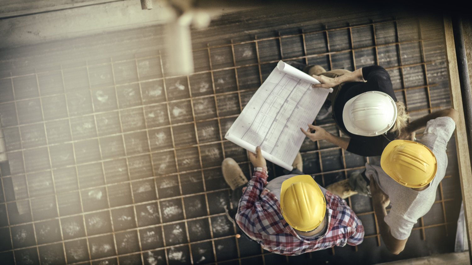 Female architect and two consruction workers on a construction site