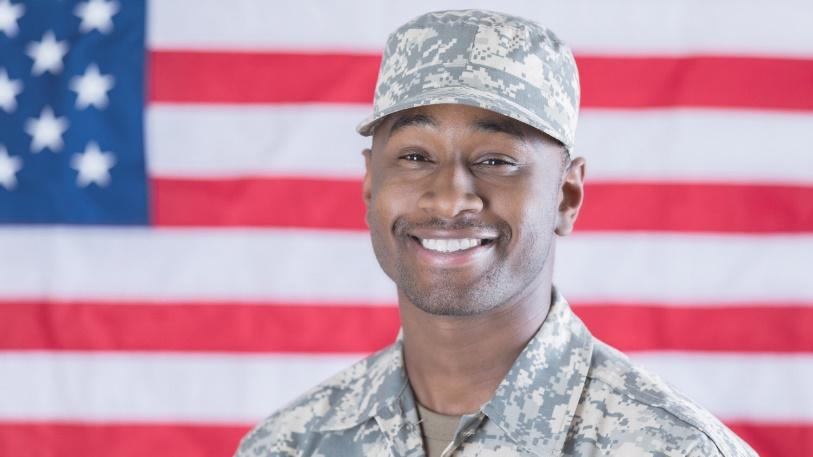 Military man in front of American flag